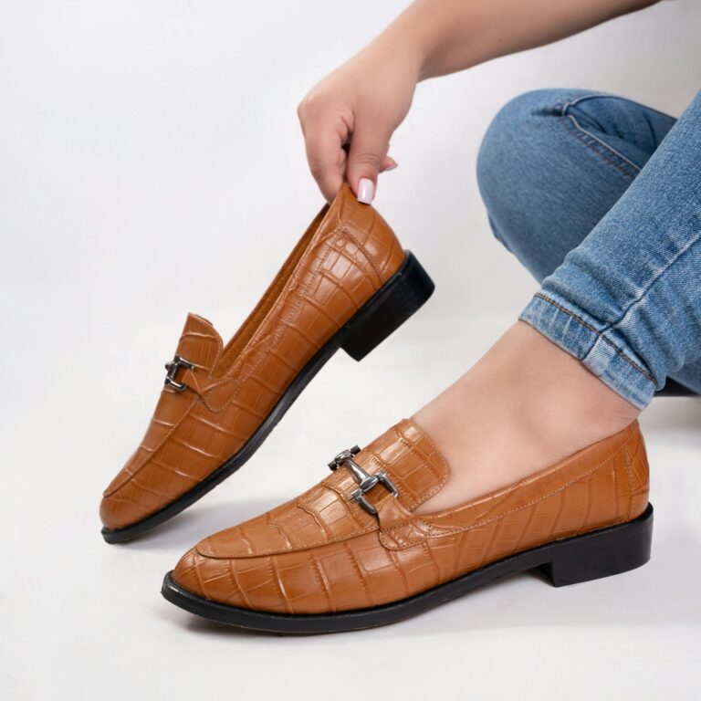 Elegant brown leather loafers with metal buckles on a white background, perfect for fashion and footwear ads.